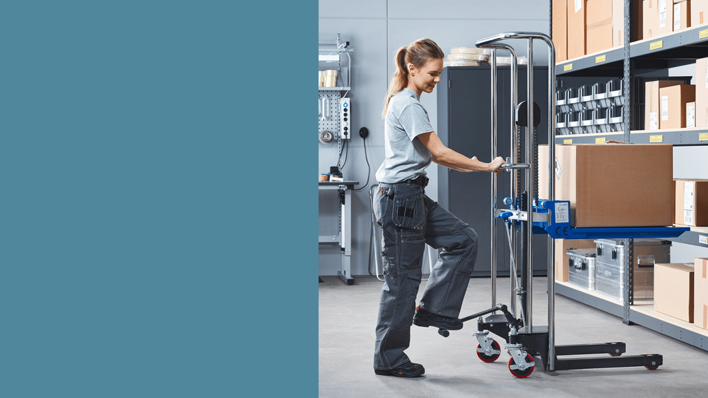 Worker packing shelves in warehouse with a lifter