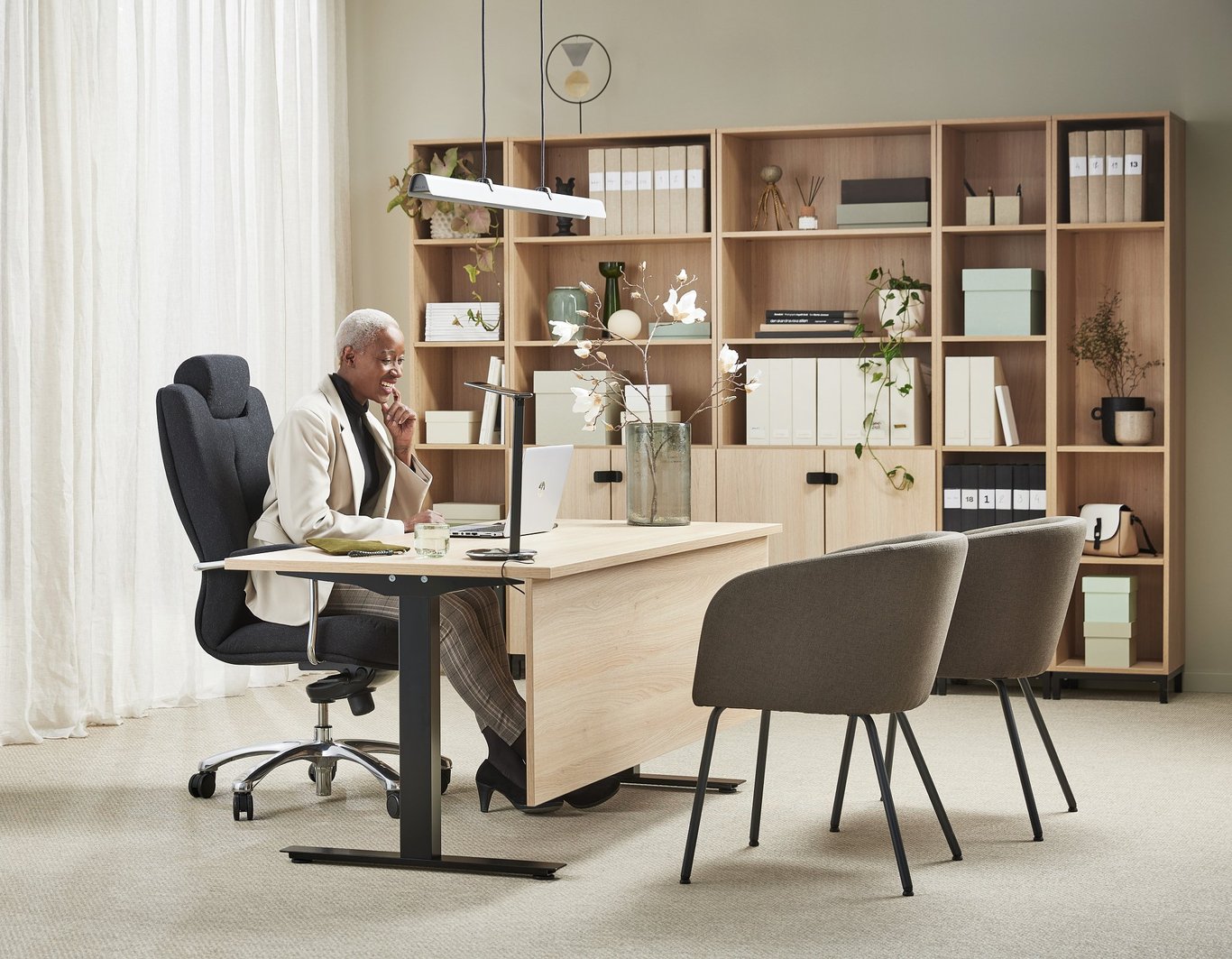 An office employee sitting on an office set with executive furniture