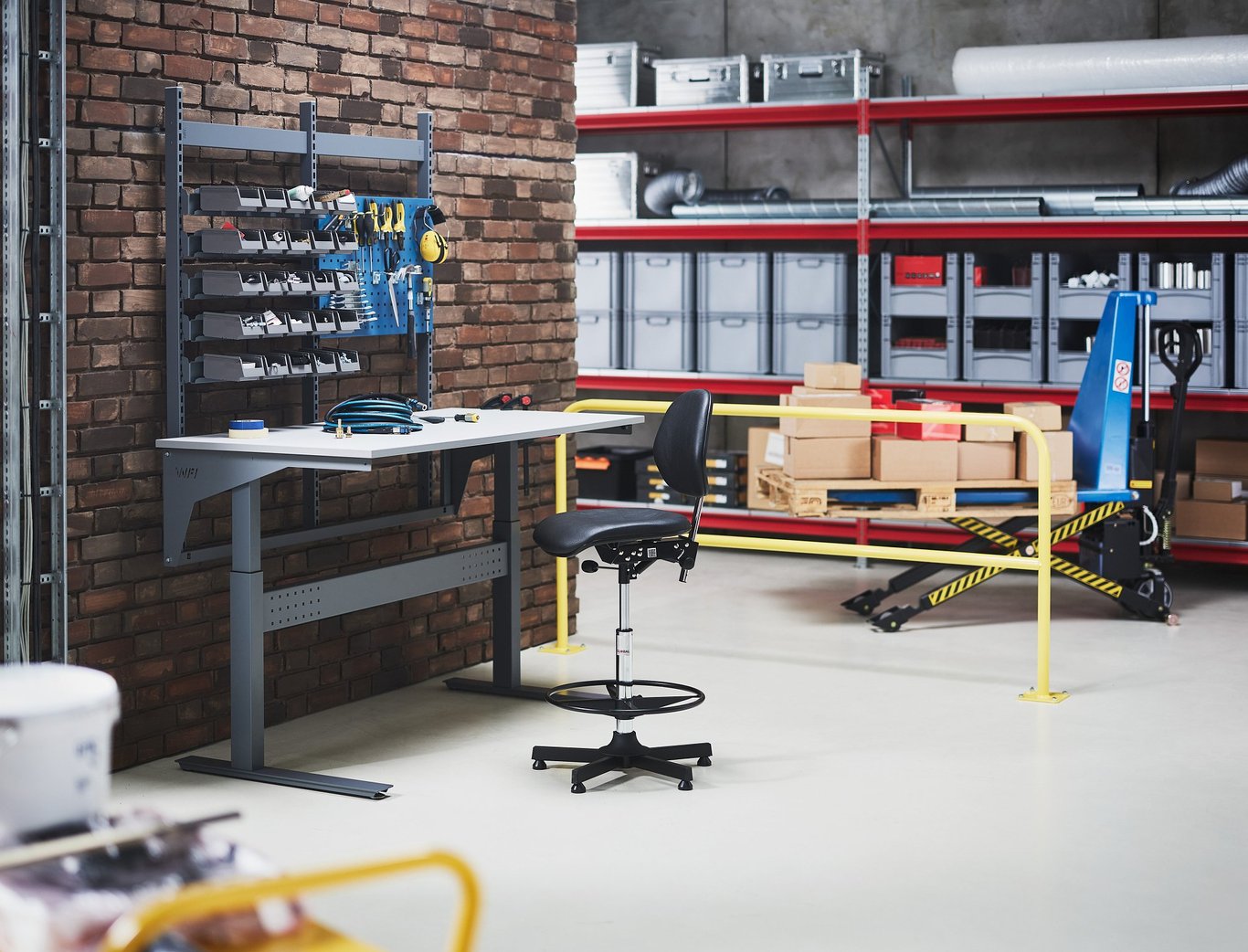 complete height adjustable workbench against a wall in a warehouse