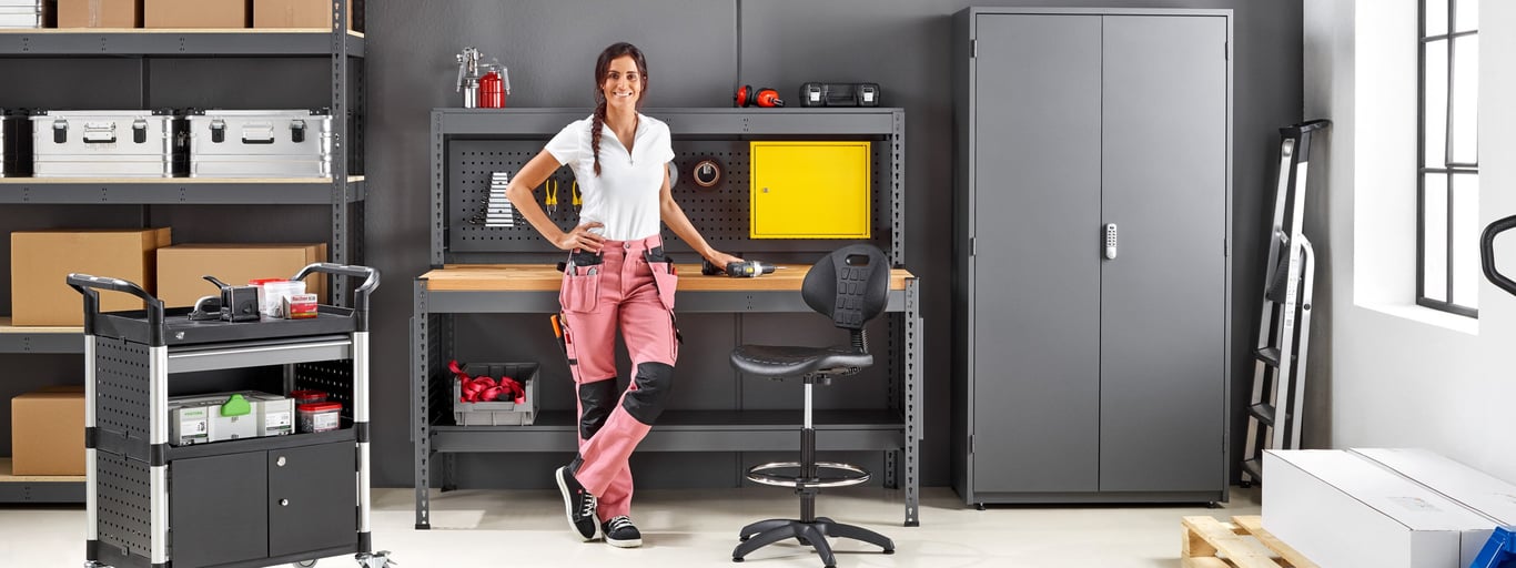 Man in a warehouse sitting by a workbench