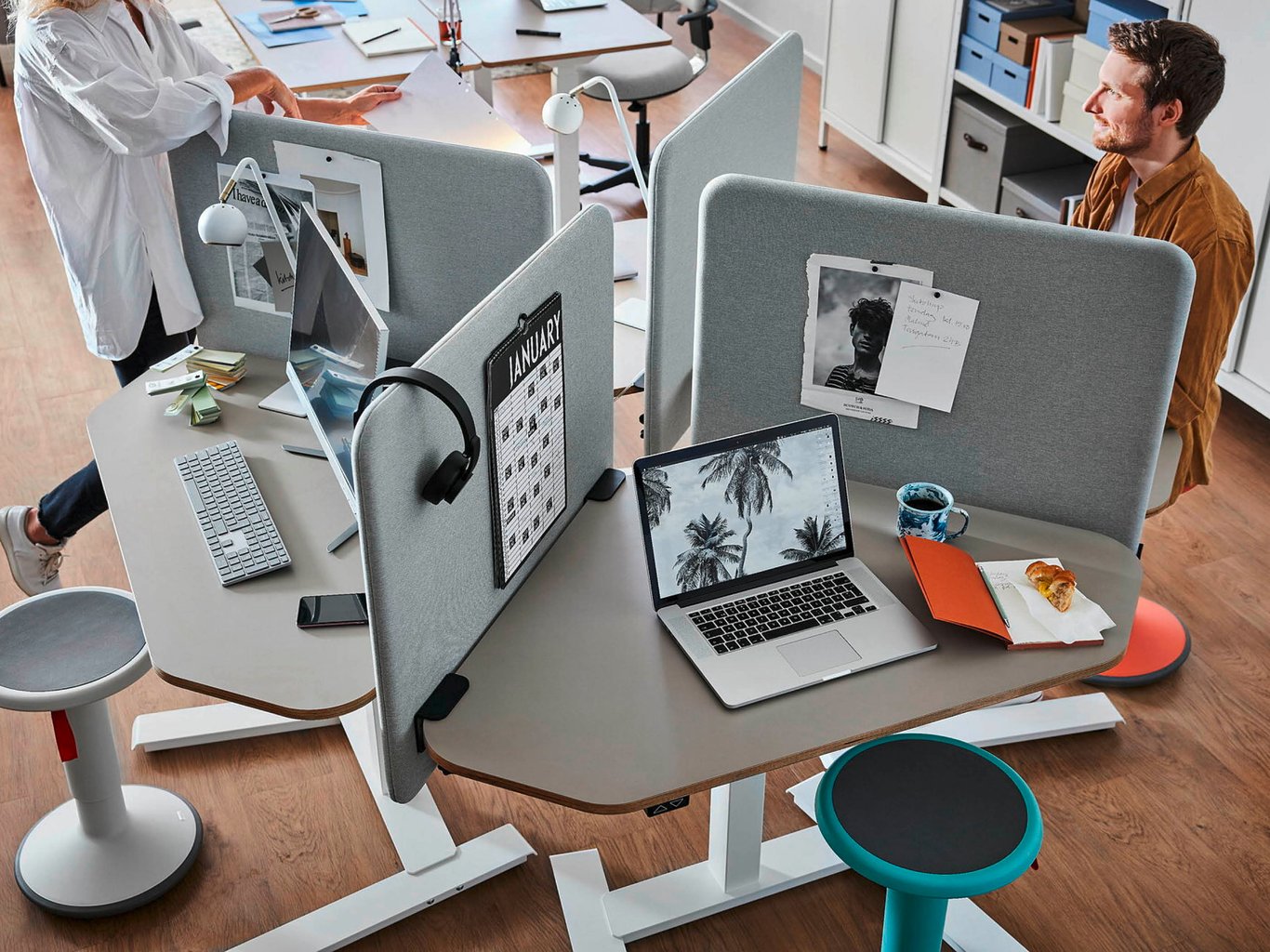 office workers chatting around a desk divided with partitions
