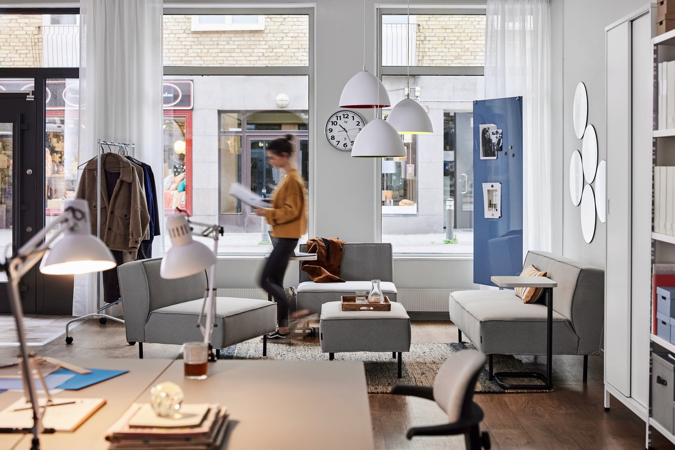 Woman walking through an office recption area  with sofas and coffee table