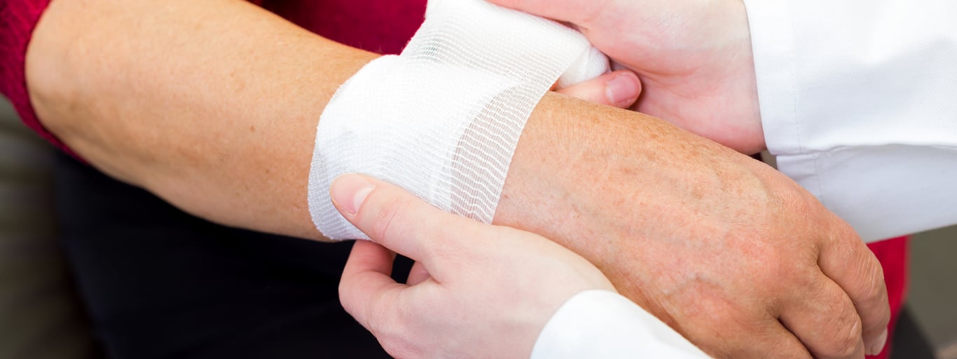 wounded person getting a wrist bandage applied