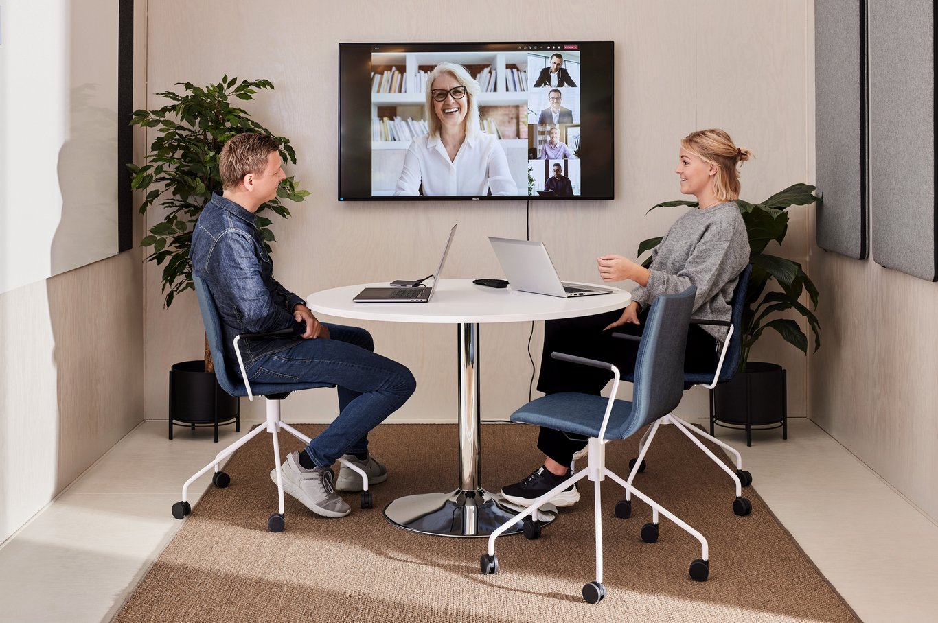 two people in a meeting room teleconferencing
