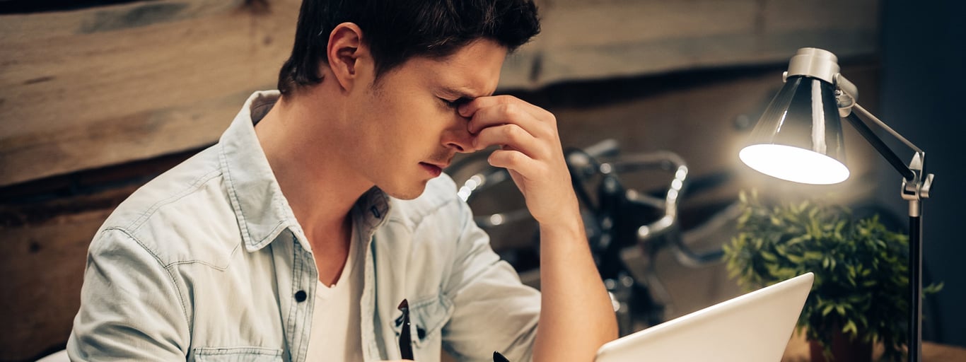 a person trying to focus in front of his laptop