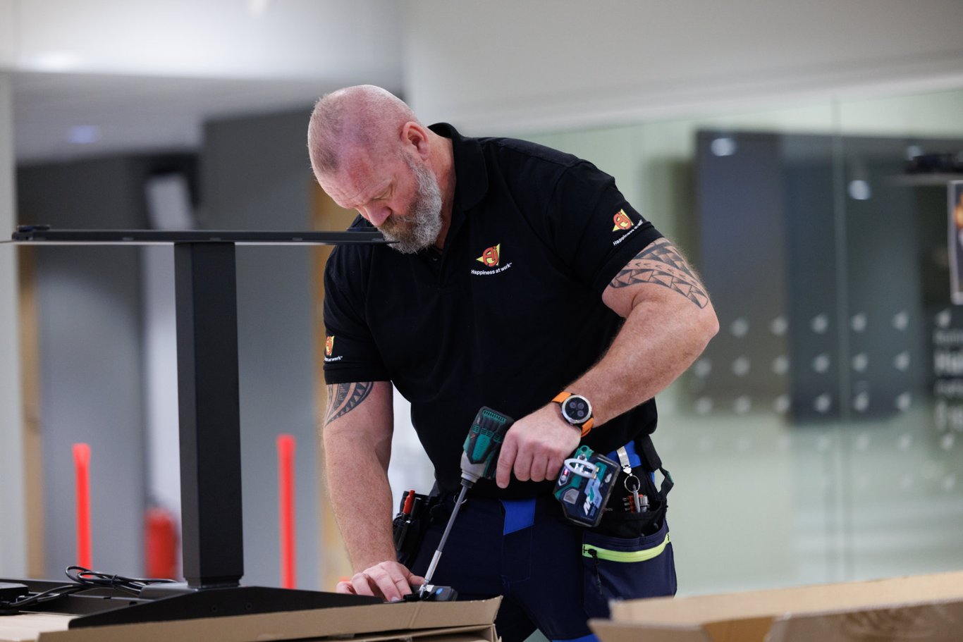 Montører som monterer kontormøbler i et kontorlandskap