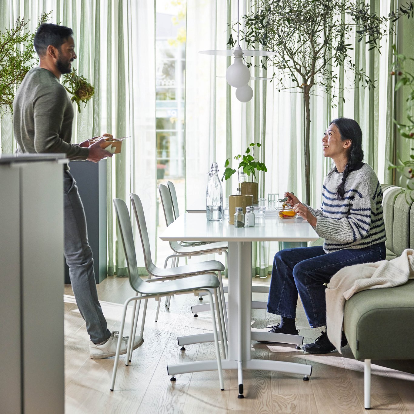 a staff member approaches his colleague while having lunch 
