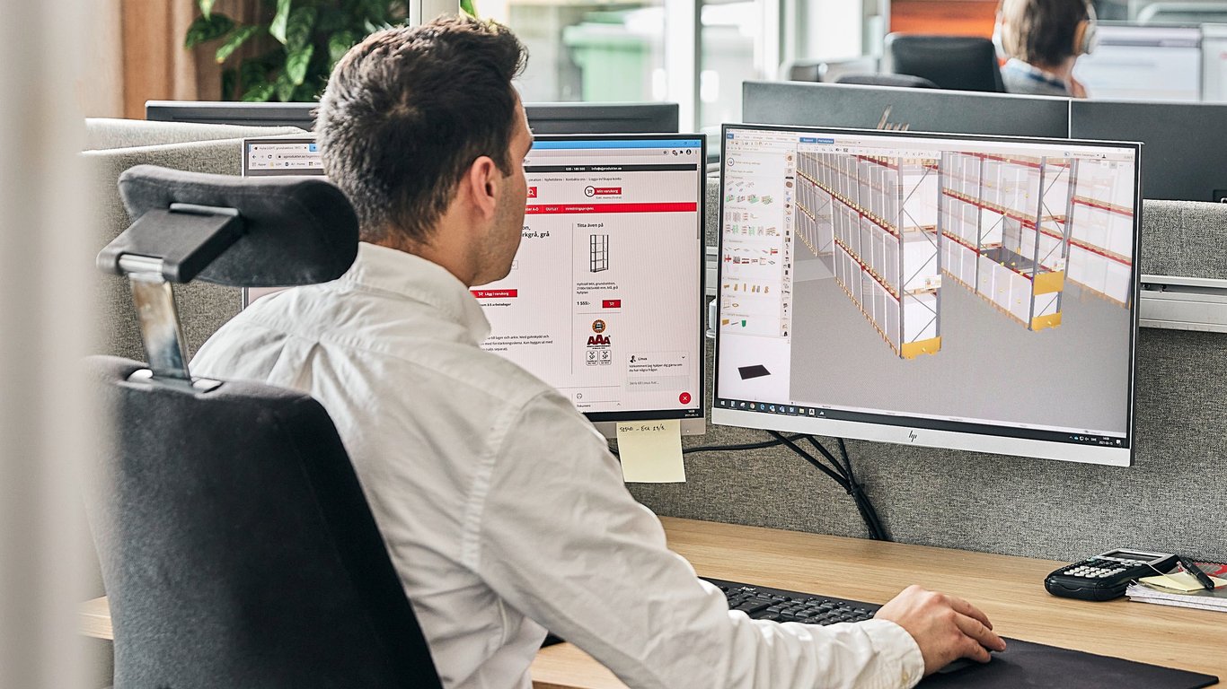 a warehouse project manager checking a 3D model of a warehouse racking system in the monitor of his computer