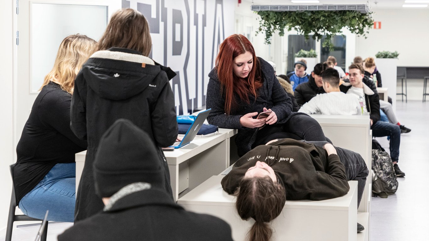 Elever som samles og sitter på benker