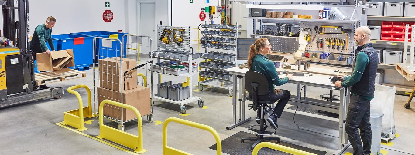 Et velorganiseret lager hvor tre lagermedarbejdere arbejder sammen