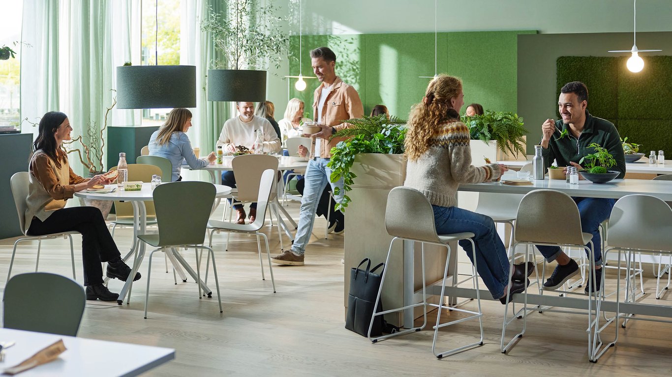 Bar stools arranged around a dining table with people sitting indoors in a dining room.  