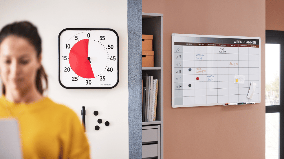 En kvinde arbejder med en time timer i baggrunden og ved siden af ses en kalender