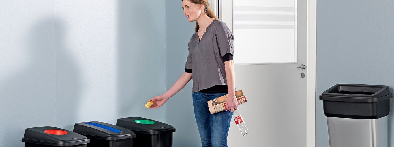 a lady using the recycling bins 