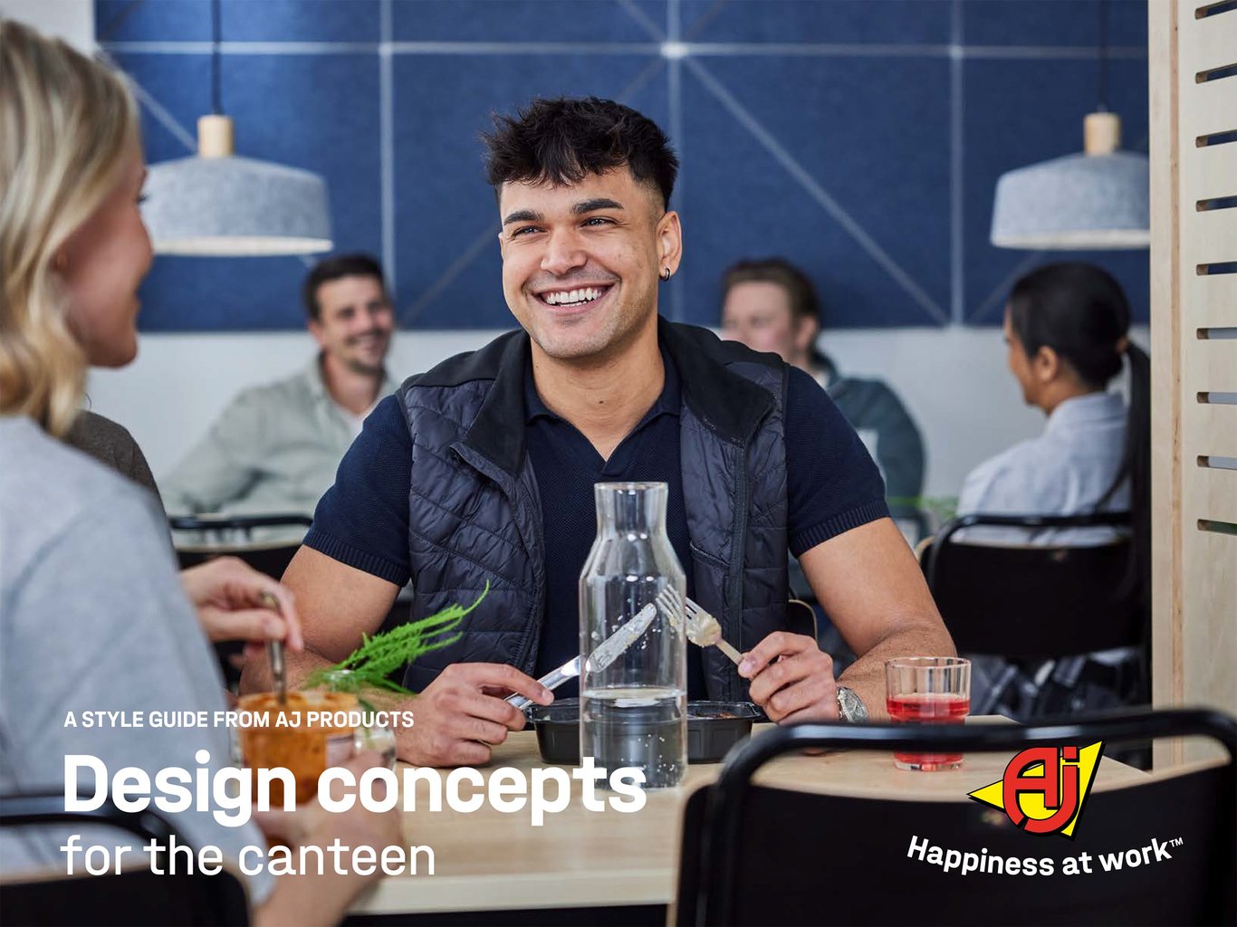 Brochure cover for Design concepts for the canteen from AJ Products. Two colleagues sitting at a wooden dining table and enjoying lunch together.