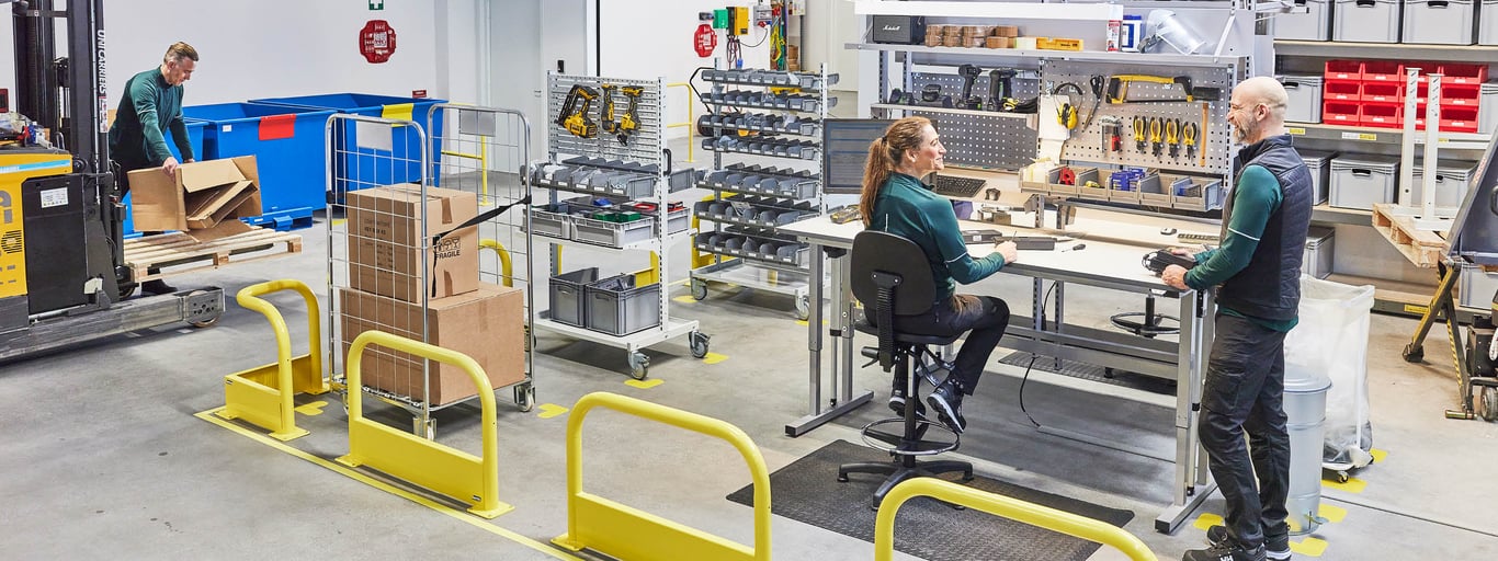 Priecīgi darbinieki ergonomiski iekārtotā noliktavā