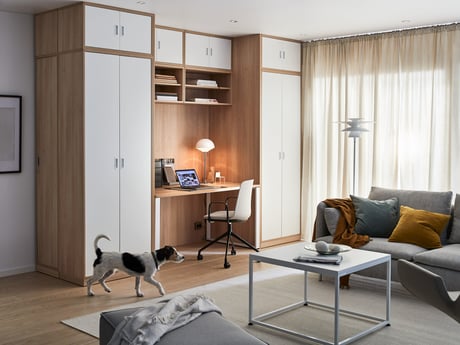 En hjemmearbejdsplads indrettet i en stue mellem skabe