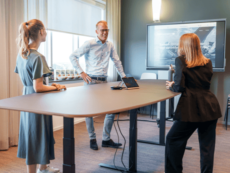 Vergaderruimte met zit-sta vergadertafel met drie personen
