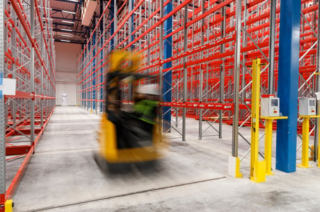 a warehouse worker moving fast through the aisles