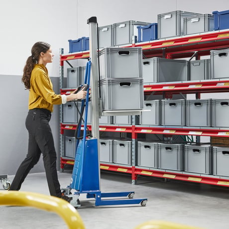 a warehouse operator using a mini stacker truck to lift a pile of boxes