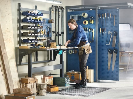 A man working at a fully equipped modern workbench