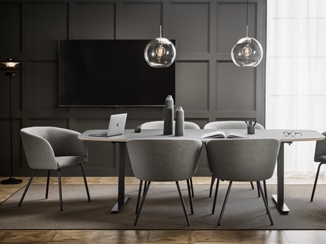 a conference room with tables and chairs arranged neatly. A TV is mounted on the wall, adding to the room functionality