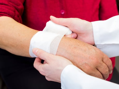 wounded person getting a wrist bandage applied