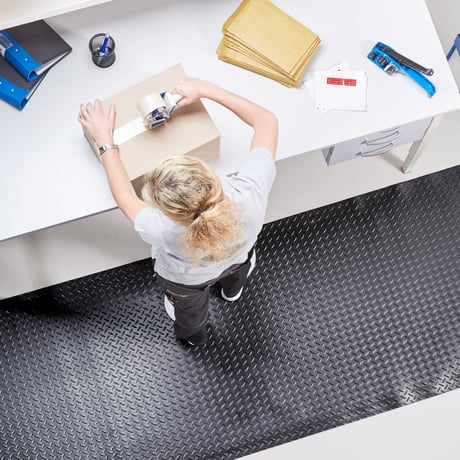 A woman packing a box at a workbench