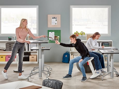 Børn, der befinder sig i et klasseværelse fyldt med borde og aktive skolemøbler