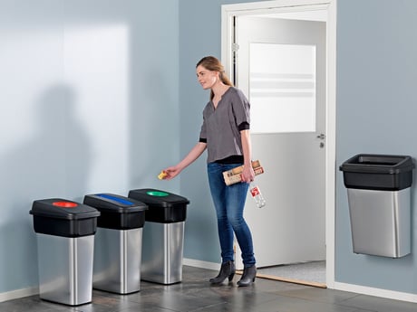 a lady using the recycling bins 