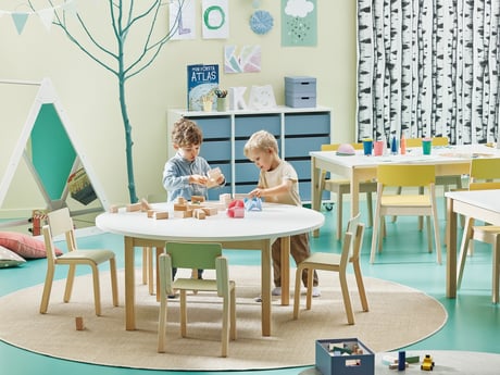 children playing around a table in a classroom