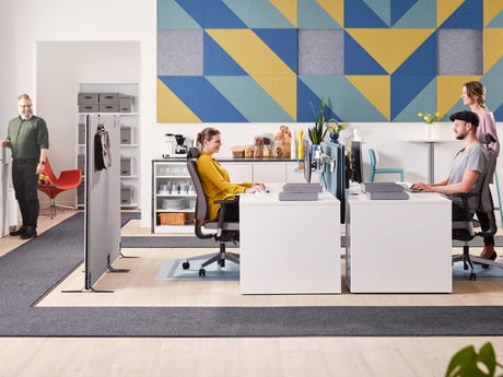 staff members in an open plan office with room dividers