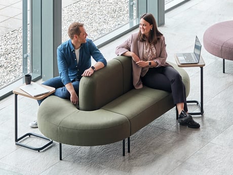 two people sitting on a sofa in a lobby