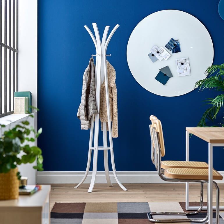 a MILLER wooden coat stand with height hooks by AJproducts against a blue wall with acoustic panels attached to it