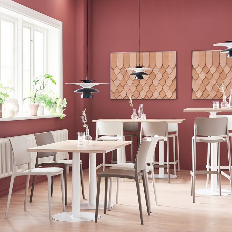 a canteen setting with simple but elegant furniture with clean lights and light-colored surfaces. On the walls there are elegant acoustic panels