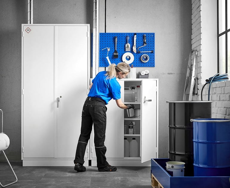 Woman using COSHH fire-resistant chemical storage cabinet