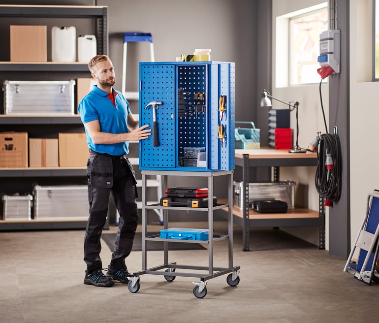 a warehouse worker pushing a tool trolley