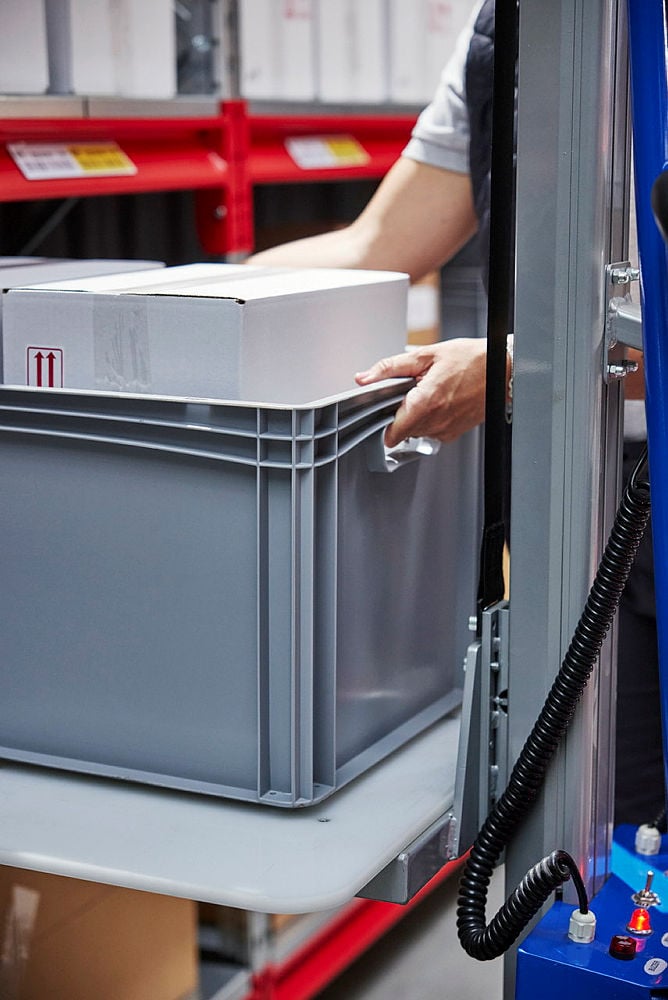 a warehouse staff member easily lifting a box to be carried out