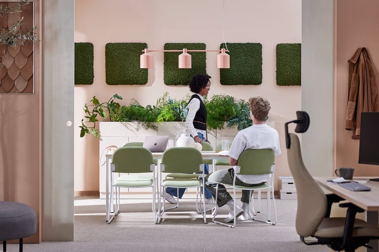 two colleagues in an open plan office connecting office space with a meeting area