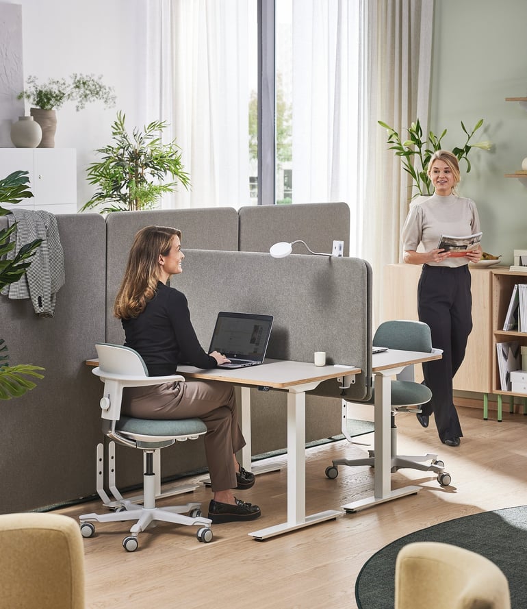 Two professionals focused on their tasks at a desk in a modern office setting.