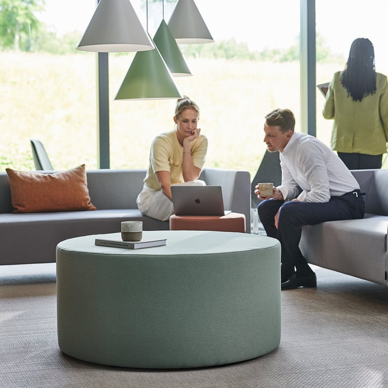 two people having an informal meeting seating side by side in a lounge area 