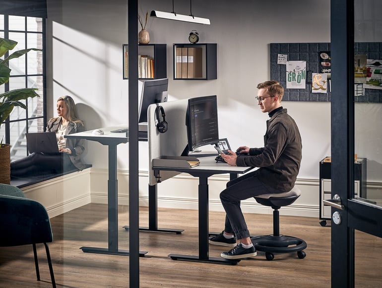 En medarbejder sidder ved sit NOMAD skrivebord og arbejder