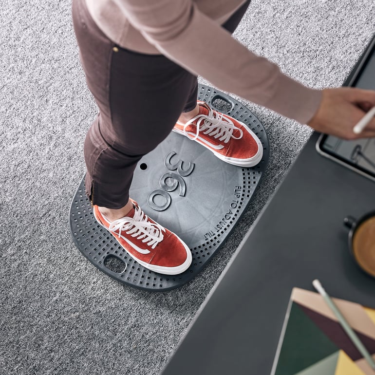 Ein Balance Board wird für die Arbeit am Stehtisch verwendet