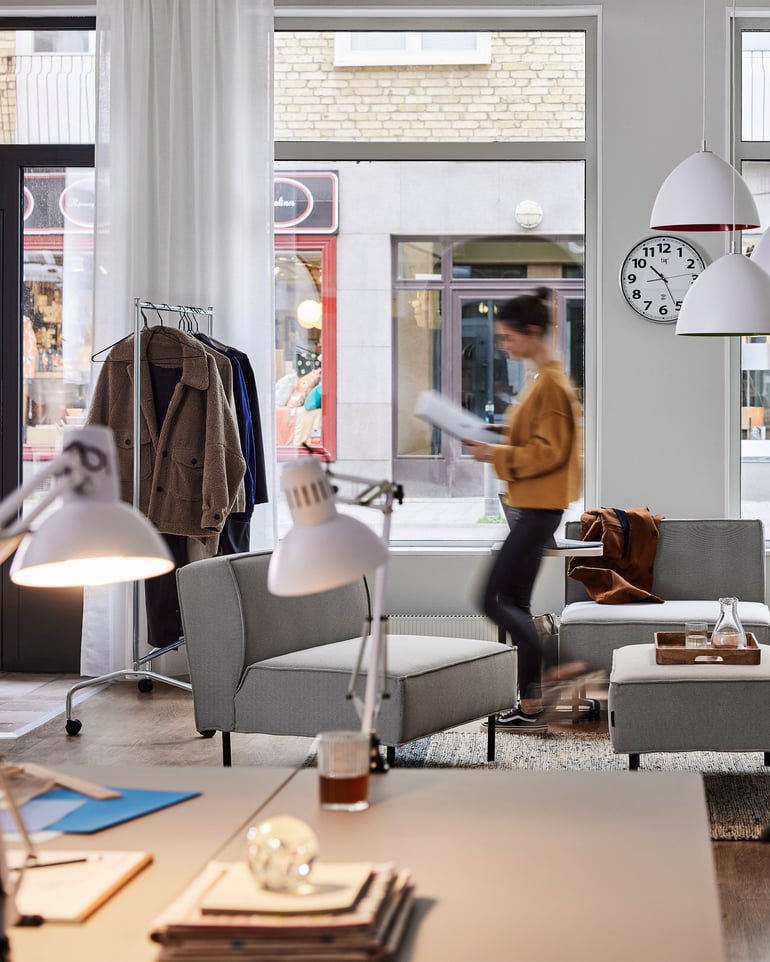 A room with a lot of natural light as well as hanging ceiling lamps and desk lamps.