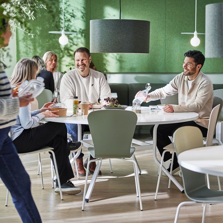 a group of staff members cheerfully enjoying their lunch break at the canteen