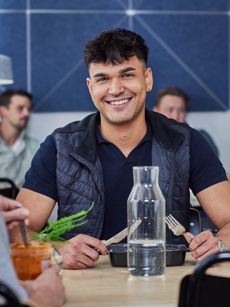 A smiling staff member having lunch at the canteen