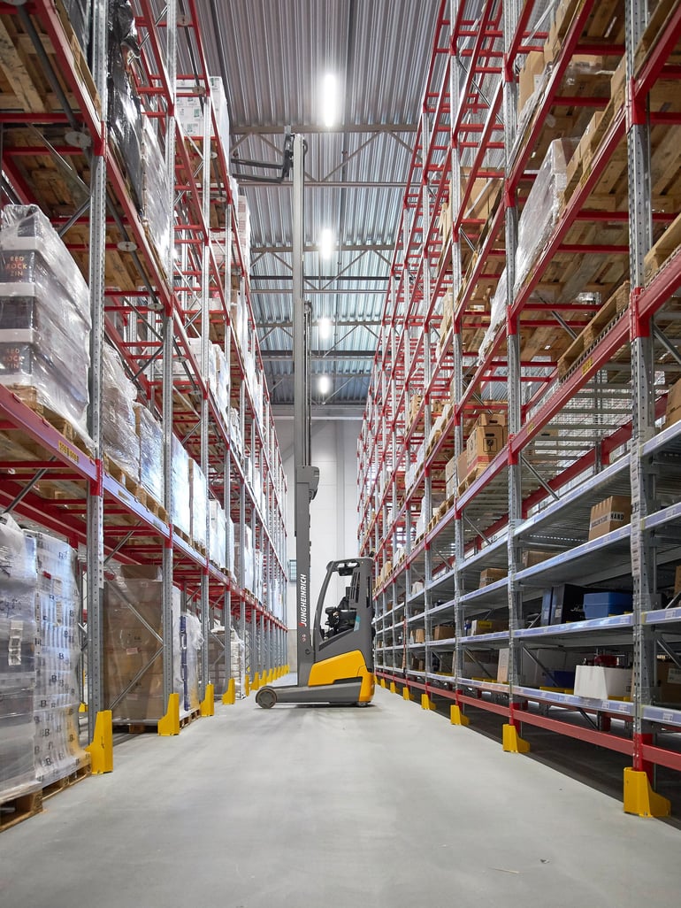 forklift between two rows of pallet racking