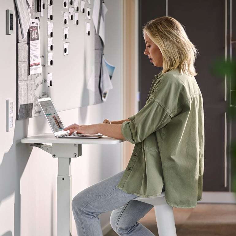 Woman working at laptop on home office desk
