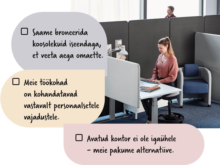 Naine istub vaheseintega eraldatud töökohas