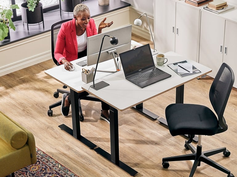 a woman in a video conference at her desk in an office space
