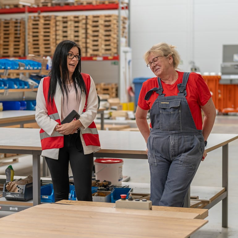 Factory manager speaks to shop floor worker